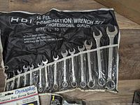 Photo showing 14-piece HDI Tools combination wrench set rolled out on floor