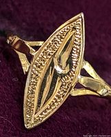 Close-up front view of the 18K gold baby ring showing the marquise-shaped top design with textured borders and smooth inner section.