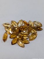 Close-up photo of multiple marquise cut genuine citrine gemstones showing facets and yellow-golden colors.