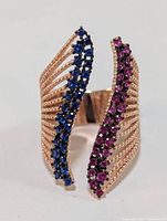 Front view of the sterling silver ring showing blue and pink cubic zirconia curved rows and split beaded band design.