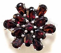 Close-up of garnet cluster ring showing floral design with multiple garnet stones set in sterling silver
