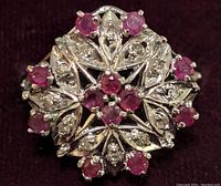 Close-up image of the sterling silver ring featuring ruby and cubic zirconia stones with detailed floral design.