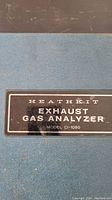 Close-up of Heathkit Exhaust Gas Analyzer model CI-1080 label on blue carrying case.