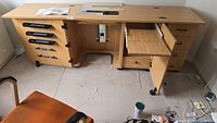 Full view of sewing cabinet showing left spool storage, central lift cut-out and right drawer section