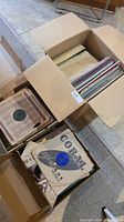 Boxes filled with vintage vinyl records, some in paper sleeves from Coral Records and others.