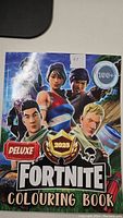 Front cover of Fortnite Deluxe Colouring Book, 2025 edition, showing characters and Deluxe label with 100+ pages