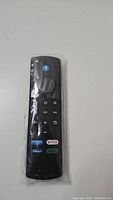 Photo of a black TV remote with buttons for Netflix, Disney+, Hulu, and Amazon Prime Video, sealed in plastic.