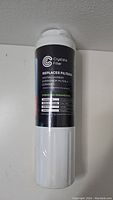 White cylindrical water filter cartridge with black label showing product details and operating parameters. The label includes brand logo Crystal Filter and a list of compatible filter models it replaces.