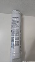 White Frigidaire water filter cartridge with model EPTWFU01 and printed usage and installation instructions.