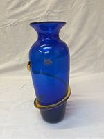 Full front view of the blue glass vase with gold spiral on white background.