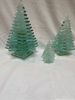 Set of three green tinted glass Christmas trees of different sizes arranged together