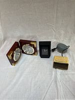 Photo showing brass and wood weather station, black plastic clock, and yellow Micronta clock with power cord