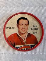 Front side of coin showing colored image of Jean Beliveau in Montreal Canadiens uniform, with 1961-62 season and number 102.