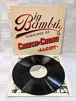 Photo showing the black vinyl record partially out of the album cover, highlighting the white label on the record and the text on the cover.