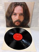 Vinyl LP record with red Polydor label shown outside of cover on protective inner sleeve.