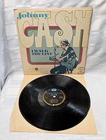 Vinyl record with label in center and cover behind it, shows condition of vinyl and cover