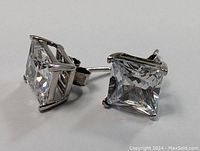 Close-up photo of the sterling silver stud earring showing the square-cut clear crystal held securely by four prongs.