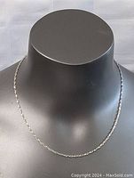 Necklace displayed on a black mannequin bust to show length and style.