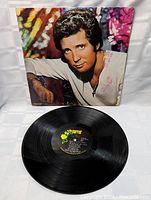 Vinyl record LP with Parrot label and album cover in background