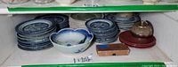Shelf view showing stacks of Blue Willow dinner and side plates with small bowls in front