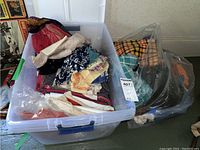 Bin of assorted printed aprons and textiles