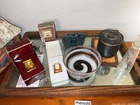 Lot displayed on a wooden mirrored tray includes perfume bottles, glass bowl, teal ceramic container, black ceramic jar with lid.