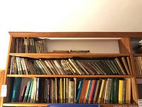 Wide shot of shelves filled with vintage hardcover and softcover books, showing varying colors, sizes, and conditions.