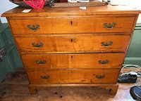 Front view of four-drawer dresser with brass bail handles showing overall condition and finish.