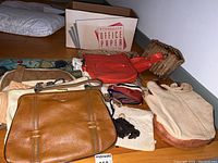Photo showing 8 different vintage purses of various materials and styles arranged on floor.