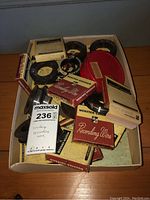 Box containing several vintage recording wire reels, some in original boxes, others loose.