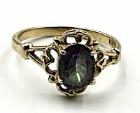 Front view of ring face showing oval green topaz set in filigree 14K gold band
