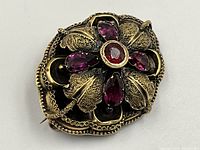 Top view of brooch showing garnet center and amethyst settings