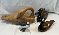 Four wooden bird carvings without size reference, showing surface details and color.