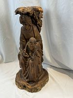 Front angle of the Madonna and Child wooden sculpture showing detailed carving of figures and clothing.