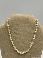 Necklace displayed on linen bust to show full length and drape