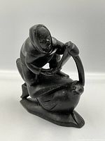 Front angled view showing hunter kneeling on seal with harpoon