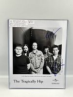 Full front view of the signed publicity photo in clear plastic sleeve