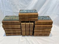 Stacked 15 leather bound Dickens volumes with marbled covers