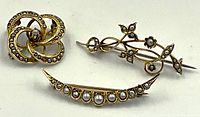 Three brooches together: crescent, openwork circular, twig motif