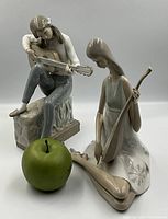 Both figurines together with green apple scale reference