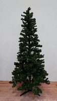 Full front view of the 6 foot assembled artificial Christmas tree on a black metal stand showing overall shape and fullness.