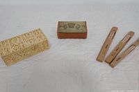 Three main items displayed: plaster cast casket on left, wooden box in center, three reed diffuser packages on right