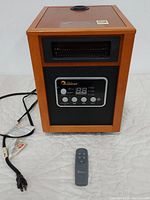 Full front view of the infrared Dr. Heater space heater showing the control panel, wood finish, power cord and remote control
