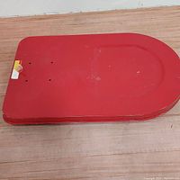 Top view of the red steel platform dolly showing the rectangular shape with rounded corners and surface holes.