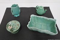Four teal-colored items: McCoy vase, small teapot, planter, and hand-painted glass dish