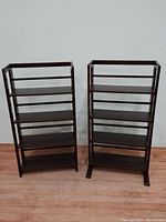 Pair of dark brown wooden folding bookcases side-by-side showing full front view.