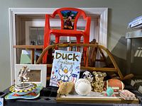 Children's toys and decor items including Mickey Mouse chair, Duck for President book, wooden furniture pieces, and piggy banks.