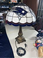 Stained glass Patriots lamp with power cord and plush toys on table