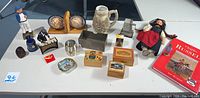 Full lot overview showing all items including wooden sailor, globe bookends, music boxes, statuette, pencil sharpeners, metal box and book.