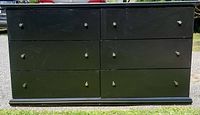 Front view of the black 6 drawer chest showing two columns of drawers with metal knobs, scratches and chips visible on surface.